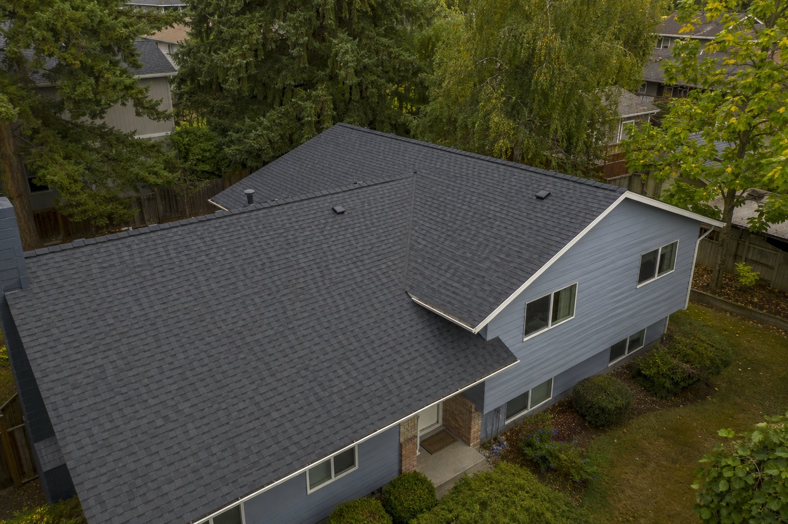 Finished roof viewed from above on a tree-lined property