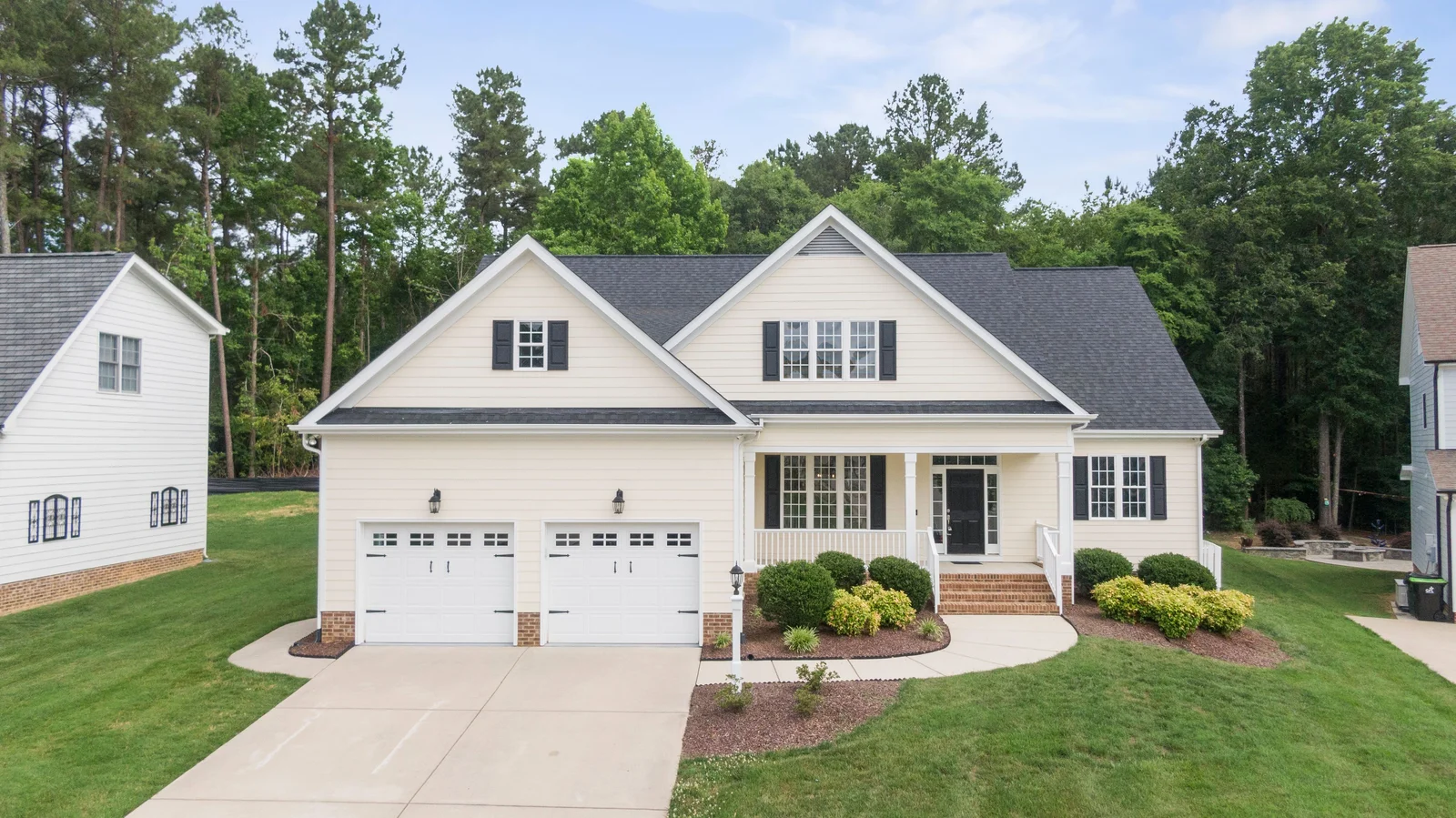 Light lap siding with white trim and dark shutters on a gabled home